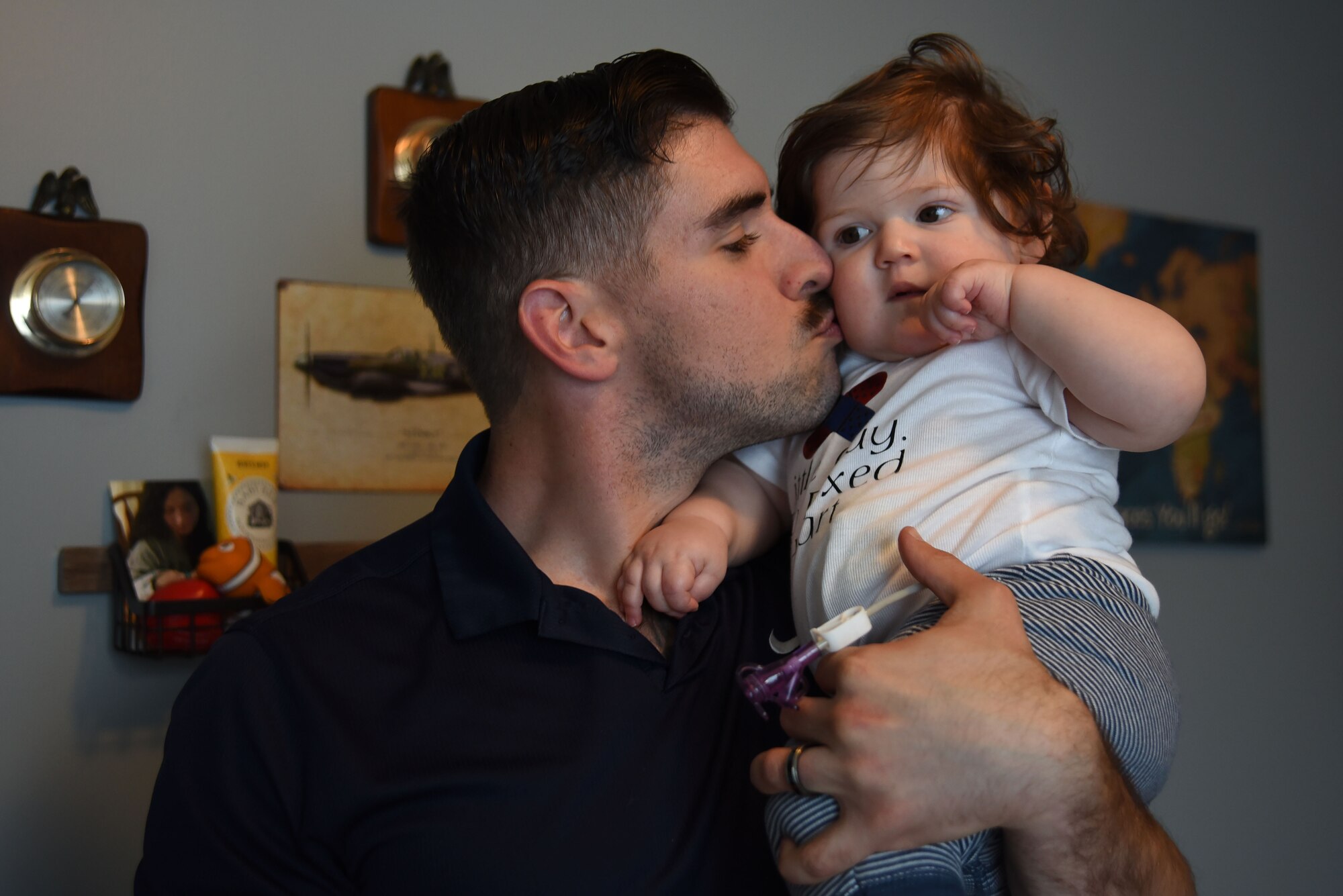 U.S. Air Force Tech. Sgt. Ben Mockovciak, 372nd Training Squadron Detachment 202 F-16 tactical aircraft maintenance instructor, gives his son, Noah Mockovciak, a kiss on the cheek while in their home at Columbia, S.C., March 15, 2018.