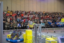 U.S. Air Force Col. Scott A. Cain (seated third from left on the front row), Arnold Engineering Development Complex commander, watches the Alliance round of the 2018 FIRST® Robotics Competition Rocket City Regional at the Von Braun Center in Huntsville, Alabama, March 17, 2018. During the Alliance round the top eight teams who placed as Alliance Team Captains during the morning’s qualifying rounds get to choose two other teams to compete with them during the final rounds for a chance at going to the FIRST® Robotics Competition World Championship in Houston, Texas in April 2018. (U.S. Air Force photo/Christopher Warner)