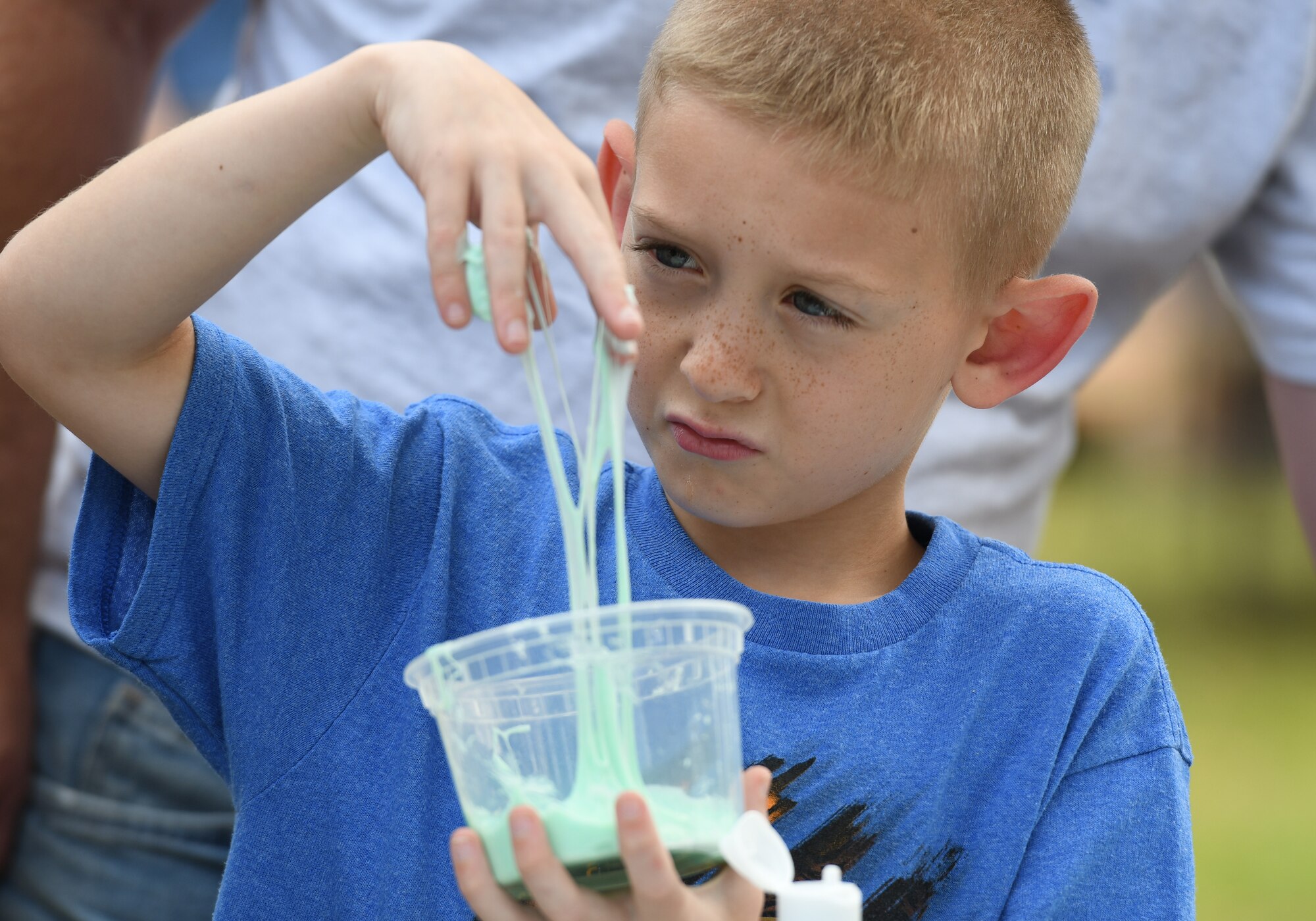 Dakota Lehman, son of U.S. Air Force Master Sgt. Todd Lehman, 924th Maintenance Squadron munitions maintenance technician, Davis-Monthan Air Force Base, Arizona, plays with a cup of slime during Child Pride Day at Marina Park at Keesler Air Force Base, Mississippi, April 21, 2018. The 81st Force Support Squadron hosted event was held in celebration of Month of the Military Child, highlighting the important role military children play in the armed forces community. Games, fun runs, pontoon boat rides and educational displays were available for military families who attended. (U.S. Air Force photo by Kemberly Groue)