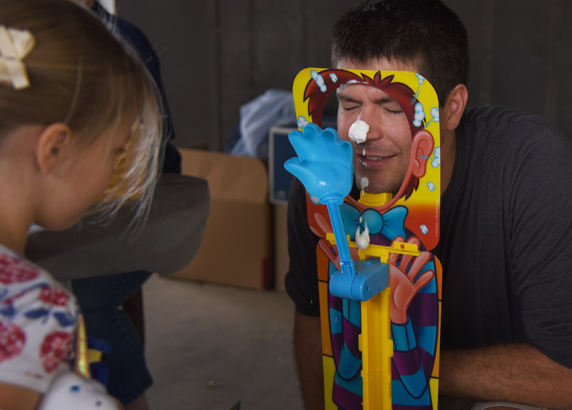 Avery Bartholomew watches her dad, U.S. Air Force Capt. Alan Bartholomew, 81st Medical Support Squadron internal medicine resident, play a game during Child Pride Day at Marina Park at Keesler Air Force Base, Mississippi, April 21, 2018. The 81st Force Support Squadron hosted event was held in celebration ofMonth of the Military Child, highlighting the important role military children play in the armed forces community. (U.S. Air Force photo by Kemberly Groue)