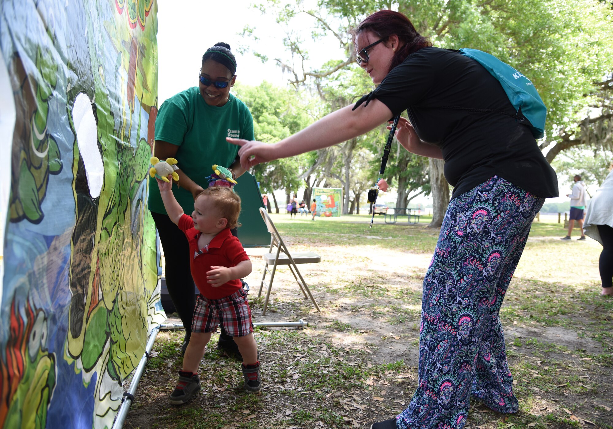 Zoelle Vautour, wife of U.S. Air Force Tech. Sgt. Vincent Vautour, 366th Training Squadron Detachment 6 instructor, Naval Construction Battalion Center, Gulfport, Mississippi, watches her son, Zacc, play Gator Gulp during Child Pride Day at Marina Park at Keesler Air Force Base, Mississippi, April 21, 2018. The 81st Force Support Squadron hosted event was held in celebration of Month of the Military Child, highlighting the important role military children play in the armed forces community. (U.S. Air Force photo by Kemberly Groue)