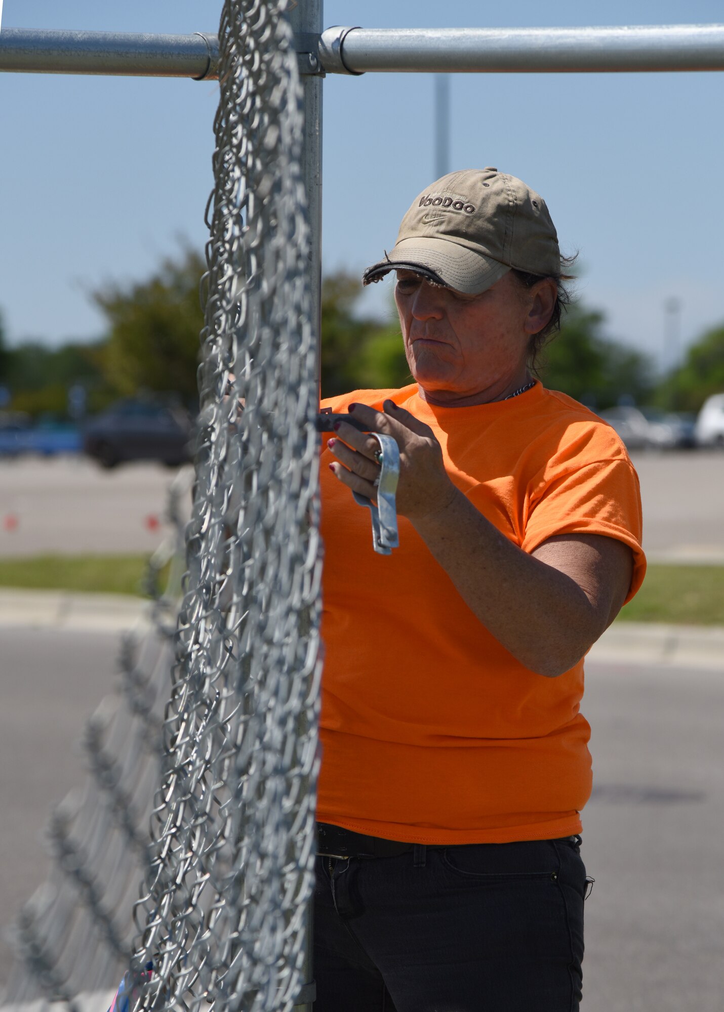 Jewell Gonzalez, Gulf Coast Fence Company laborer, secures fencing in the open grass area near the commissary at Keesler Air Force Base, Mississippi, April 10, 2018. The fence will serve as a perimeter around the site of the new Division Street Gate entrance construction. The estimated $37 million project will begin construction this summer. (U.S. Air Force photo by Kemberly Groue)