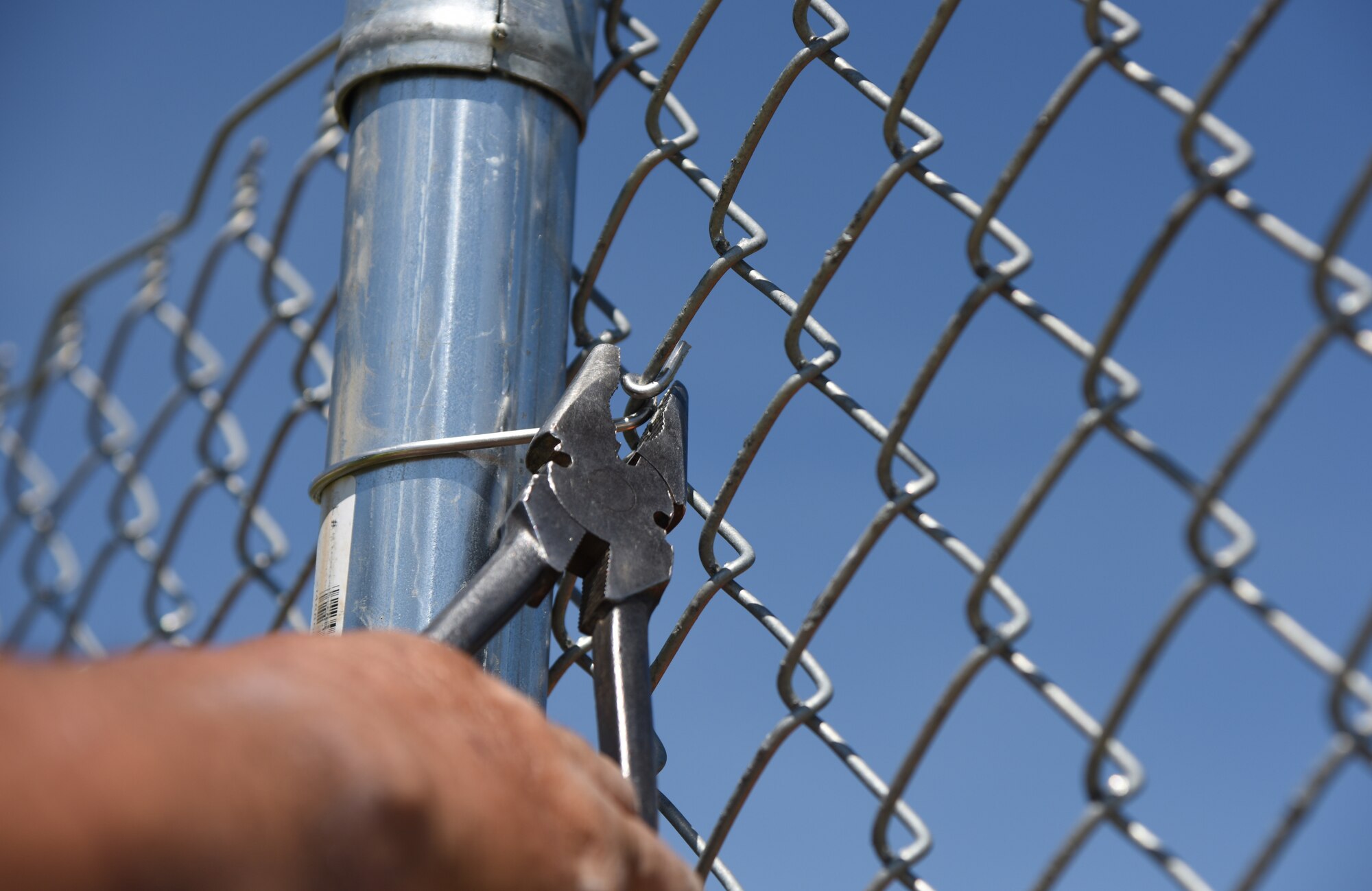 Donald Gonzalez, Gulf Coast Fence Company superintendent, secures fencing in the open grass area near the commissary at Keesler Air Force Base, Mississippi, April 10, 2018. The fence will serve as a perimeter around the site of the new Division Street Gate entrance construction. The estimated $37 million project will begin construction this summer. (U.S. Air Force photo by Kemberly Groue)