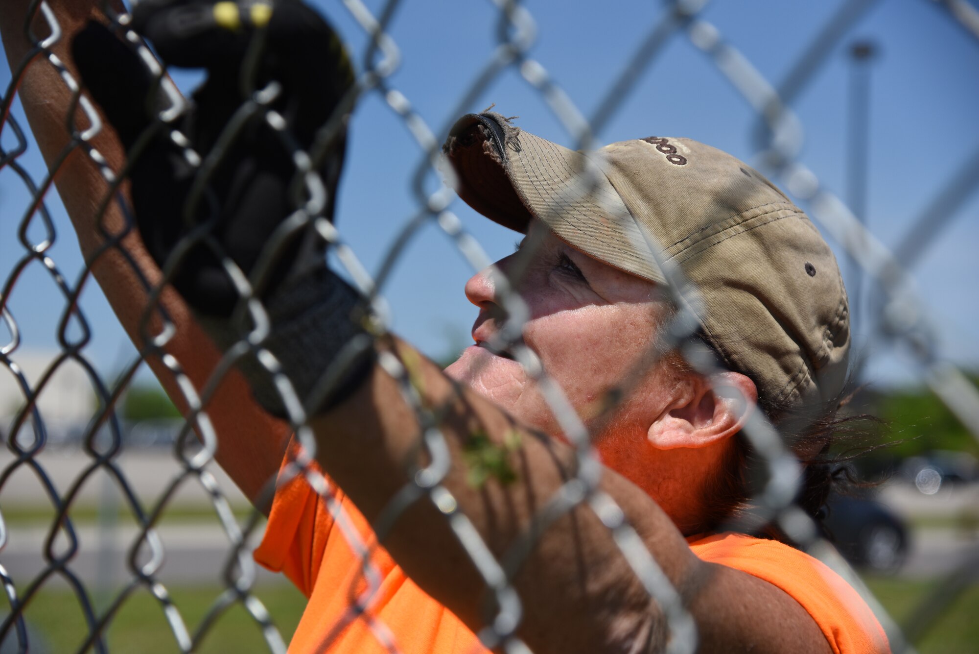 Jewell Gonzalez, Gulf Coast Fence Company laborer, installs fencing in the open grass area near the commissary at Keesler Air Force Base, Mississippi, April 10, 2018. The fence will serve as a perimeter around the site of the new Division Street Gate entrance construction. The estimated $37 million project will begin construction this summer. (U.S. Air Force photo by Kemberly Groue)