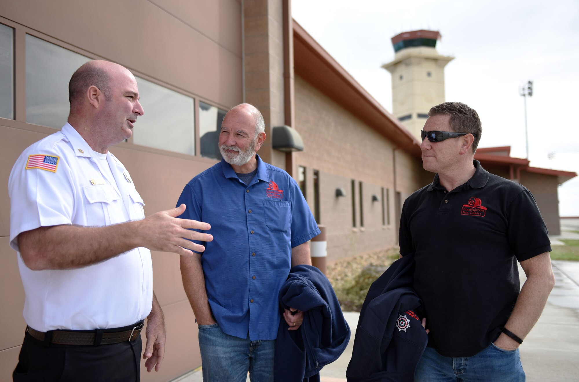 John Speakman, Travis Fire Emergency Services chief, left, stands with Steve Vucrevich, chapter leader for North Bay Firefighters for Christ, center, and Owen Spiers, a Belfast firefighter and Northern Ireland FFC representative, during a meet and greet session April 11 at Travis Air Force Base, Calif. Speakman has led efforts in the past to contribute Travis' FFC chapter to help in various charitable causes in the local community (U.S. Air Force photo by Airman 1st Class Christian Conrad)