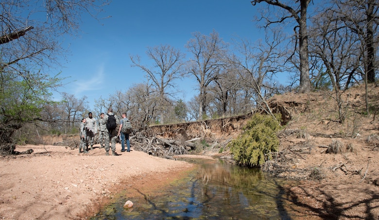 Senior Airman Philip Lee, a contracting specialist assigned to the 97th Contracting Squadron, leaps over a creek during a contracting contingency exercise, April 18, 2018, Fort Sill, Okla. Contracting Airmen from five different bases came together to exercise Operational Contract Support in a deployed environment. (U.S. Air Force photo by Airman Jeremy Wentworth)