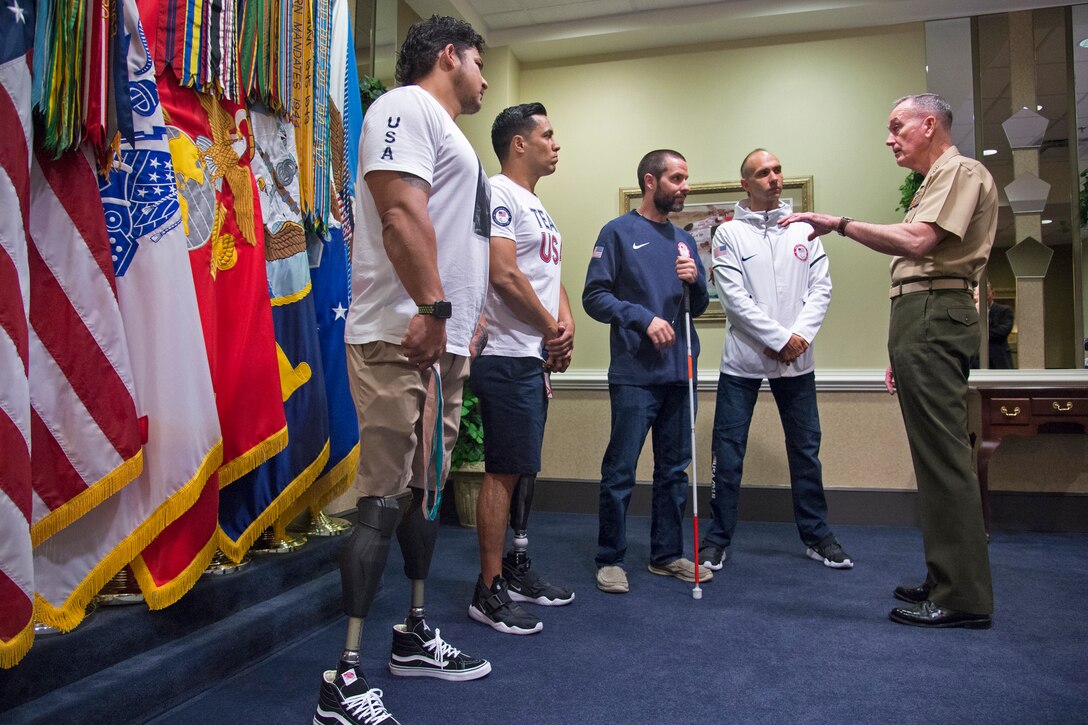 Marine Corps Gen. Joe Dunford, chairman of the Joint Chiefs of Staff, stands with four Paralympains.