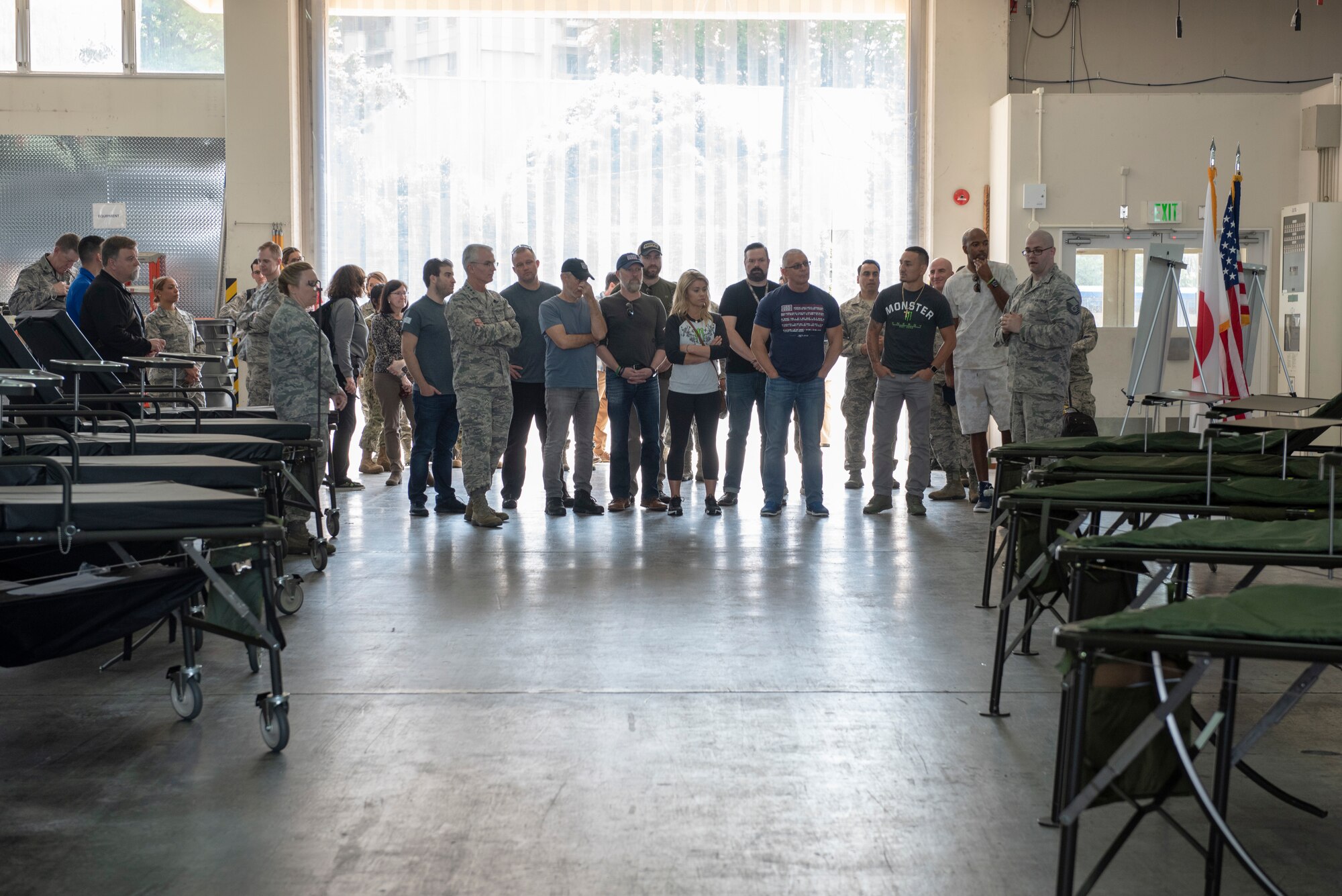 Master Sgt. Bradley Allred, 374th Medical Support Squadron medical contingency operations section chief, explains the initial staging portion of the En Route Patient Staging System to the members of the USO Spring Tour at Yokota Air Base, Japan, April 22, 2018.