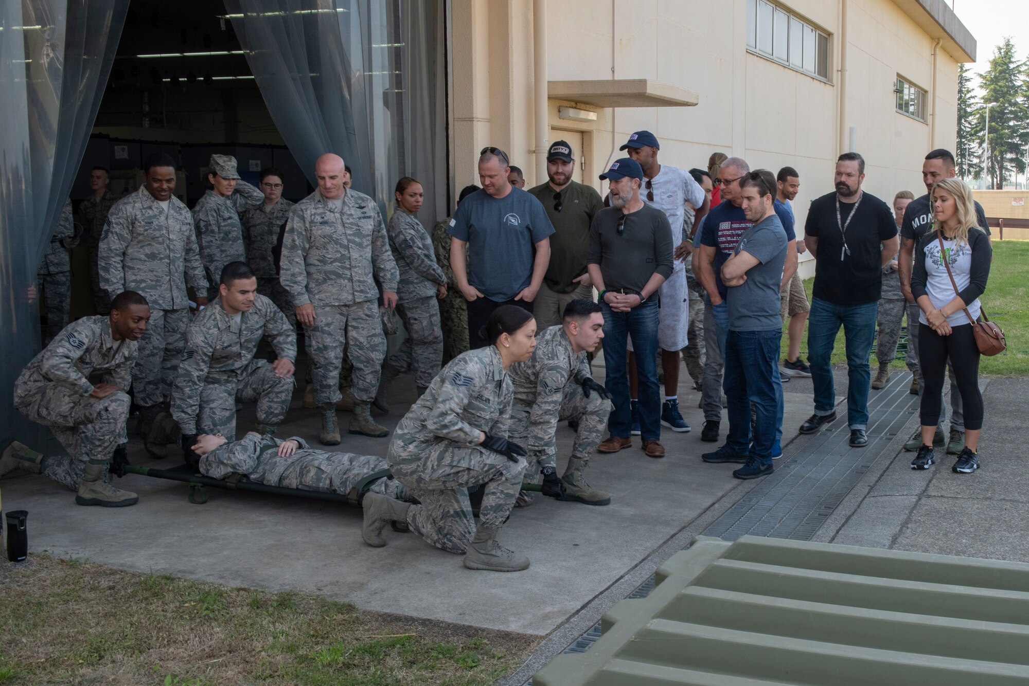 Airmen from the 374th Medical Support Squadron prepare to lift a gurney in demonstration of the En Route Patient Staging System for the members of the USO Spring Tour at Yokota Air Base, Japan, April 22, 2018.