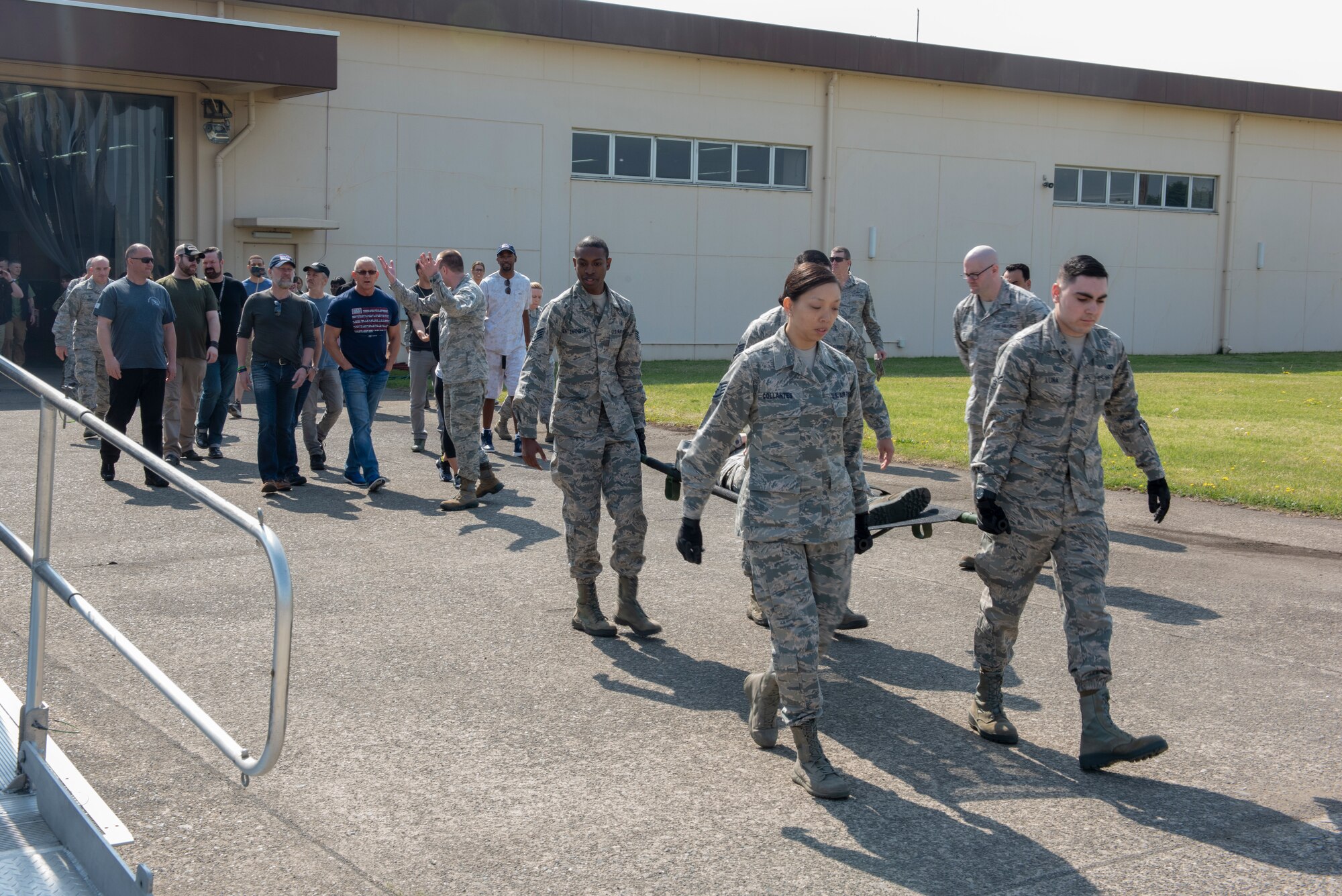 Airmen from the 374th Medical Support Squadron carry a gurney in demonstration of the En Route Patient Staging System for the members of the USO Spring Tour at Yokota Air Base, Japan, April 22, 2018.