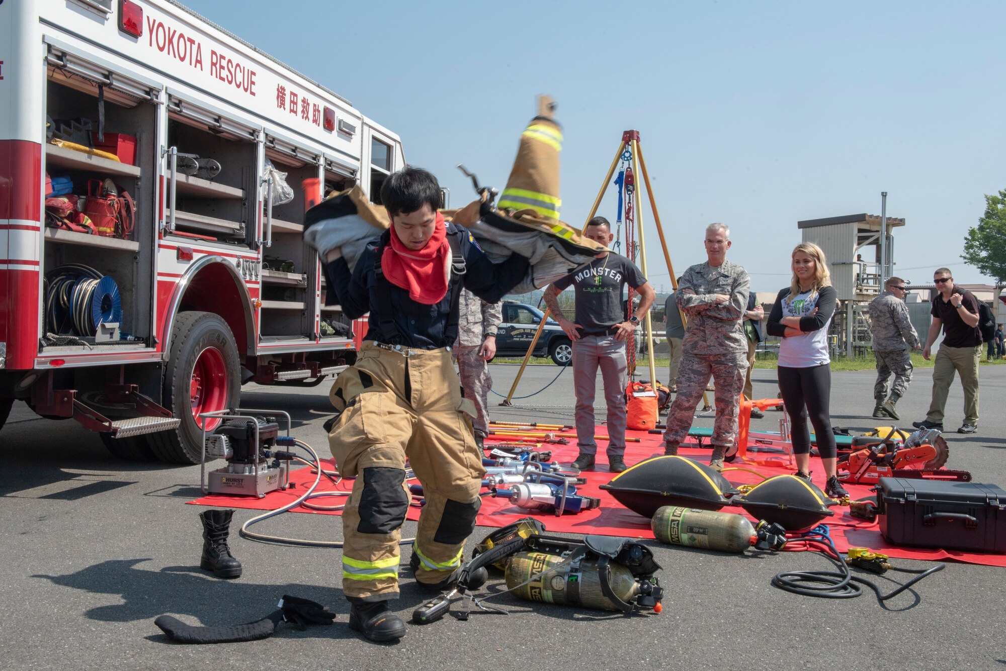 Kento Atari, 374th Civil Engineer Squadron firefighter, races against the clock to don all of his equipment in under a minute for USO Spring Tour entertainers Max Holloway and Paige VanZant and tour Host, Gen. Paul Selva, Vice Chairman of the Joint Chiefs of Staff, at Yokota Air Base, Japan, April 22, 2018.