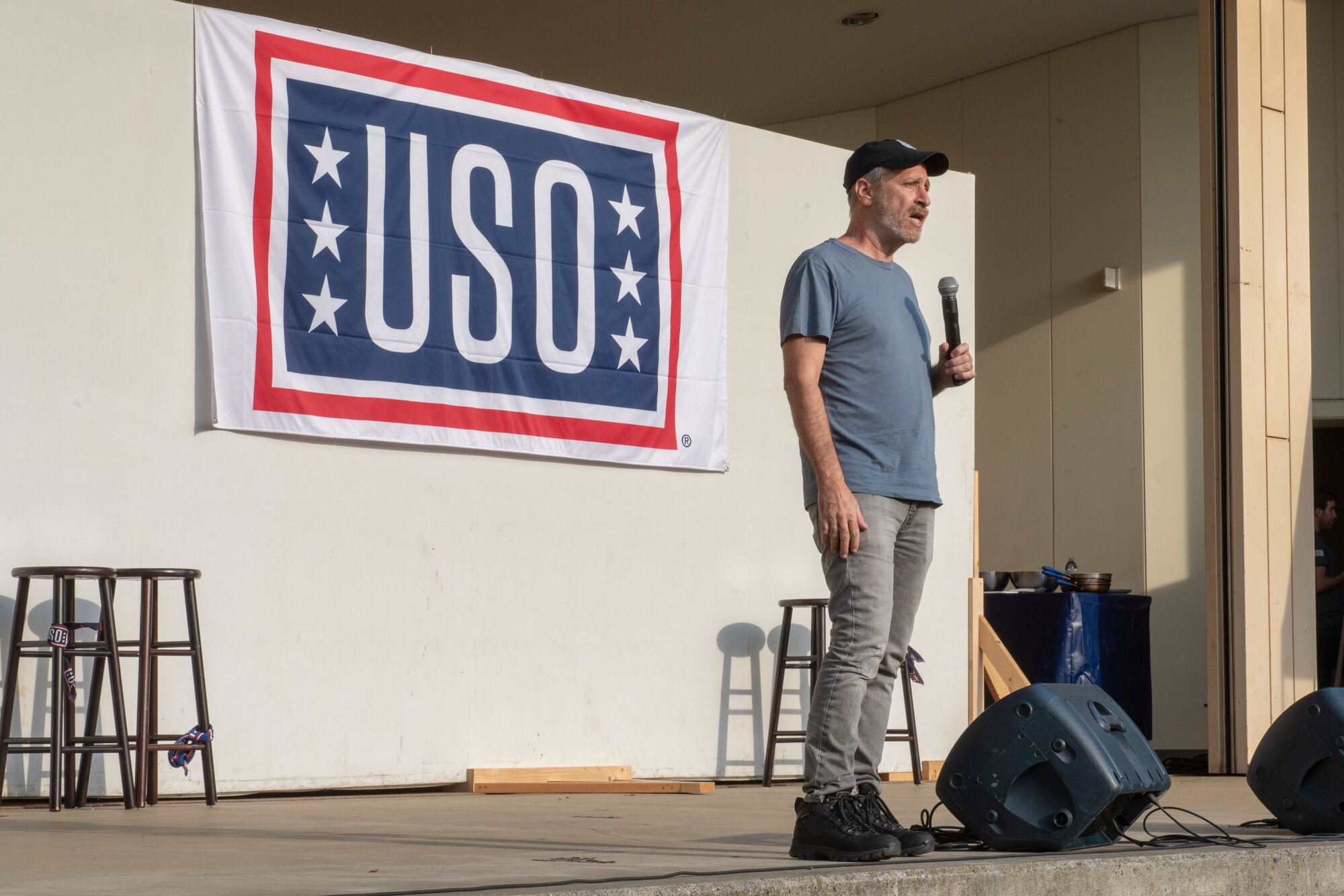 Jon Stewart, famous comedian, writer, producer and director, performs a comedic introduction to the service members in attendance at the USO Spring Tour at Yokota Air Base, Japan, April 22, 2018.