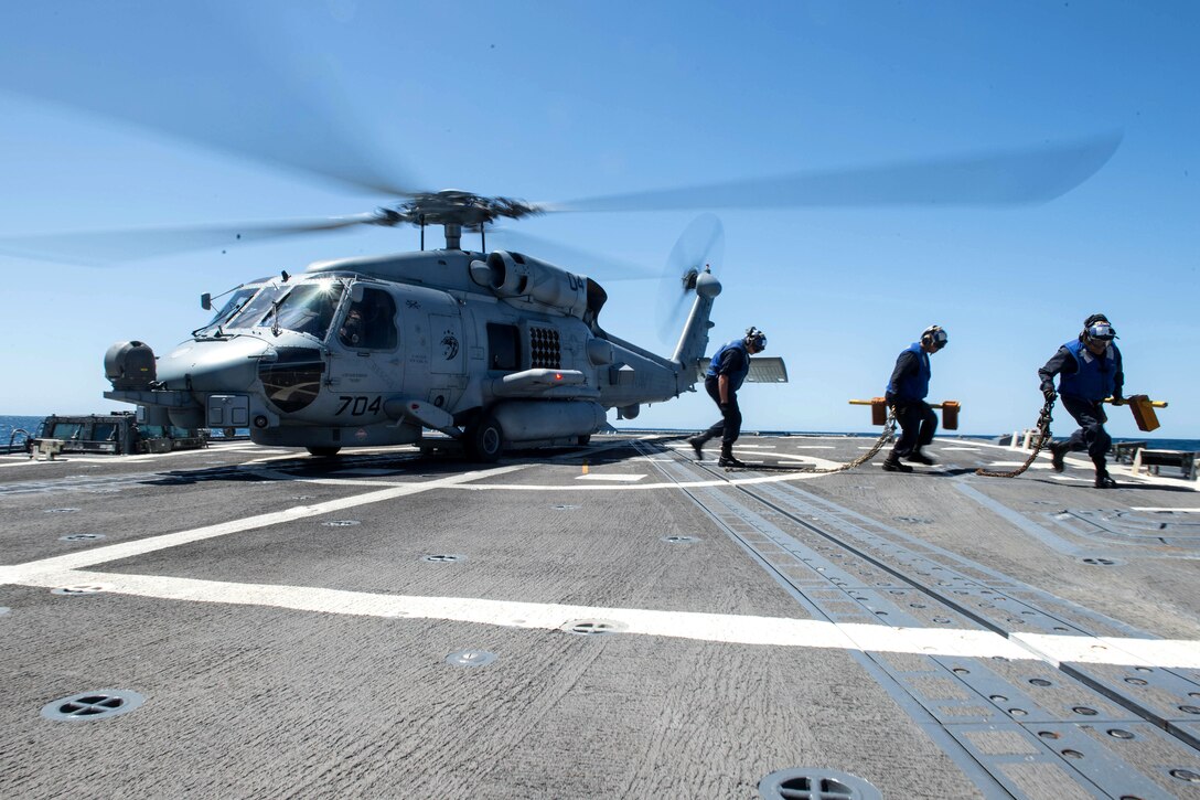 Sailors unsecure an MH-60S Knighthawk helicopter.