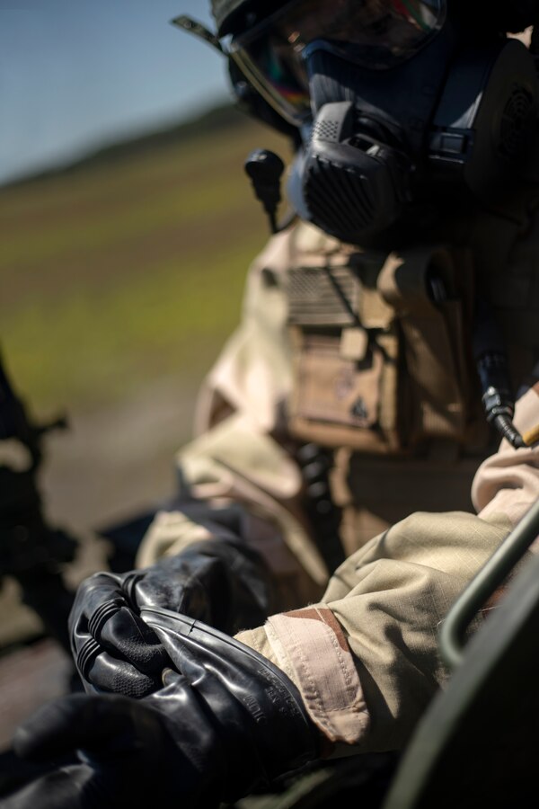 Cpl. Alexander Thompson, a vehicle commander with Alpha Company, 2nd Light Armored Reconnaissance Battalion, 2nd Marine Division, puts on Mission Oriented Protective Posture gear during annual gunnery qualification training at Camp Lejeune, N.C., April 21, 2018. The unit incorporated MOPP gear into their training, which is designed to protect them from chemical, biological, radiological and nuclear environments, and maintain Marines’ readiness to fight in any situation. (U.S. Marine Corps photo by Cpl. Aaron Henson)
