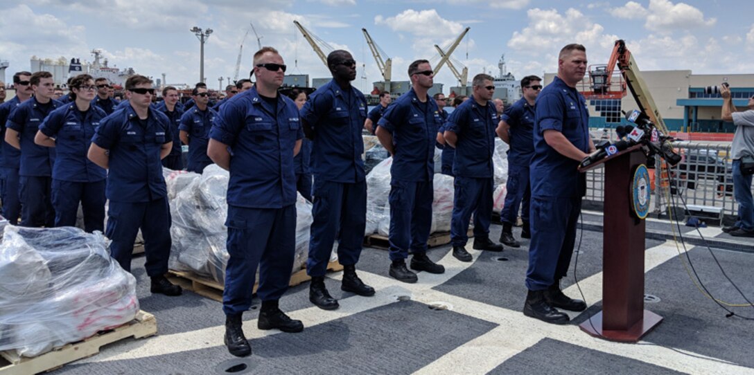 A Coast Guard officer conducts a press conference.