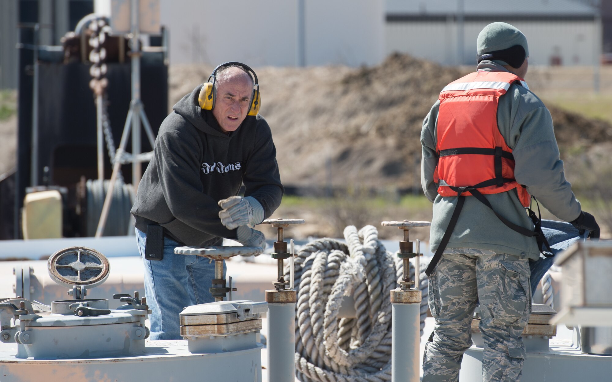 Jeff Jenkins, barge captain, opens a fuel tank so that the Airmen from 733rd Logistics Readiness Squadron fuel laboratory can run tests, at Joint Base Langley-Eustis, Virginia, March 23, 2018. The LRS Airmen must test the fuel to check if it contains any water before they can begin pumping. (U.S. Air Force photo by Airman 1st Class Tristan Biese)