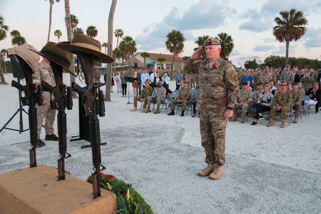 U.S. Army Gen. Raymond A. Thomas III, commander, U.S. Special Operations Command, salutes after placing a wreath on an Anzac Day memorial during a dawn service on the beach at MacDill Air Force Base, April 25. Personnel from U.S. Central Command, U.S. Special Operations Command, and other base commands attended the commemoration service that marks the anniversary of the military campaign on the Gallipoli Peninsula fought by Australian and New Zealand forces during World War I.  Anzac Day also commemorates the lives lost by Australians and New Zealanders during World War II and subsequent military and peacekeeping operations. (Photo by Tom Gagnier)