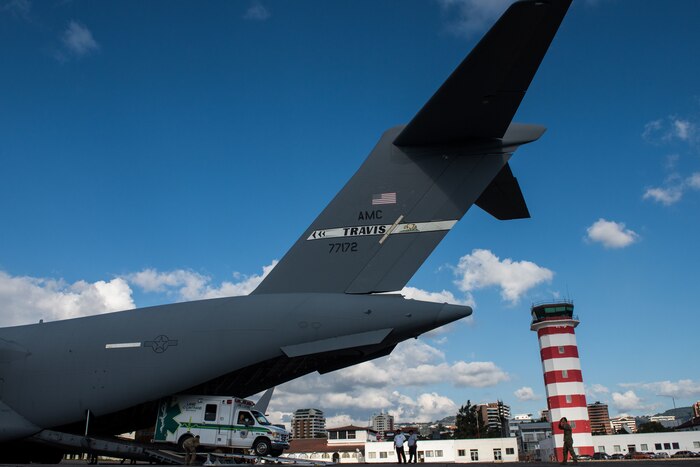 A firetruck is unloaded from a military aircraft at an airport in Guatemala.