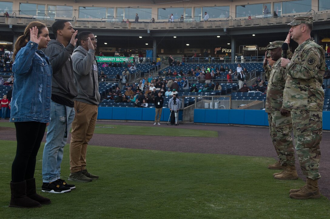 (Right) U.S. Army Col. Ralph Clayton, 733rd Mission Support Group commander, administers the oath of enlistment for three recruits at Fort Eustis Night during a Norfolk Tides game at Harbor Park, Virginia, April 21, 2018. Fort Eustis, Virginia is celebrating its 100 years and remembering the variety of missions it has supported since 1918. (U.S. Air Force photo by Senior Airman Derek Seifert)