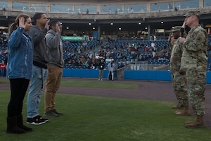 (Right) U.S. Army Col. Ralph Clayton, 733rd Mission Support Group commander, administers the oath of enlistment for three recruits at Fort Eustis Night during a Norfolk Tides game at Harbor Park, Virginia, April 21, 2018. Fort Eustis, Virginia is celebrating its 100 years and remembering the variety of missions it has supported since 1918. (U.S. Air Force photo by Senior Airman Derek Seifert)
