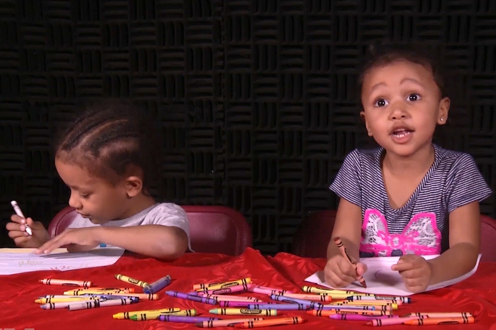 Two children draw at a table.