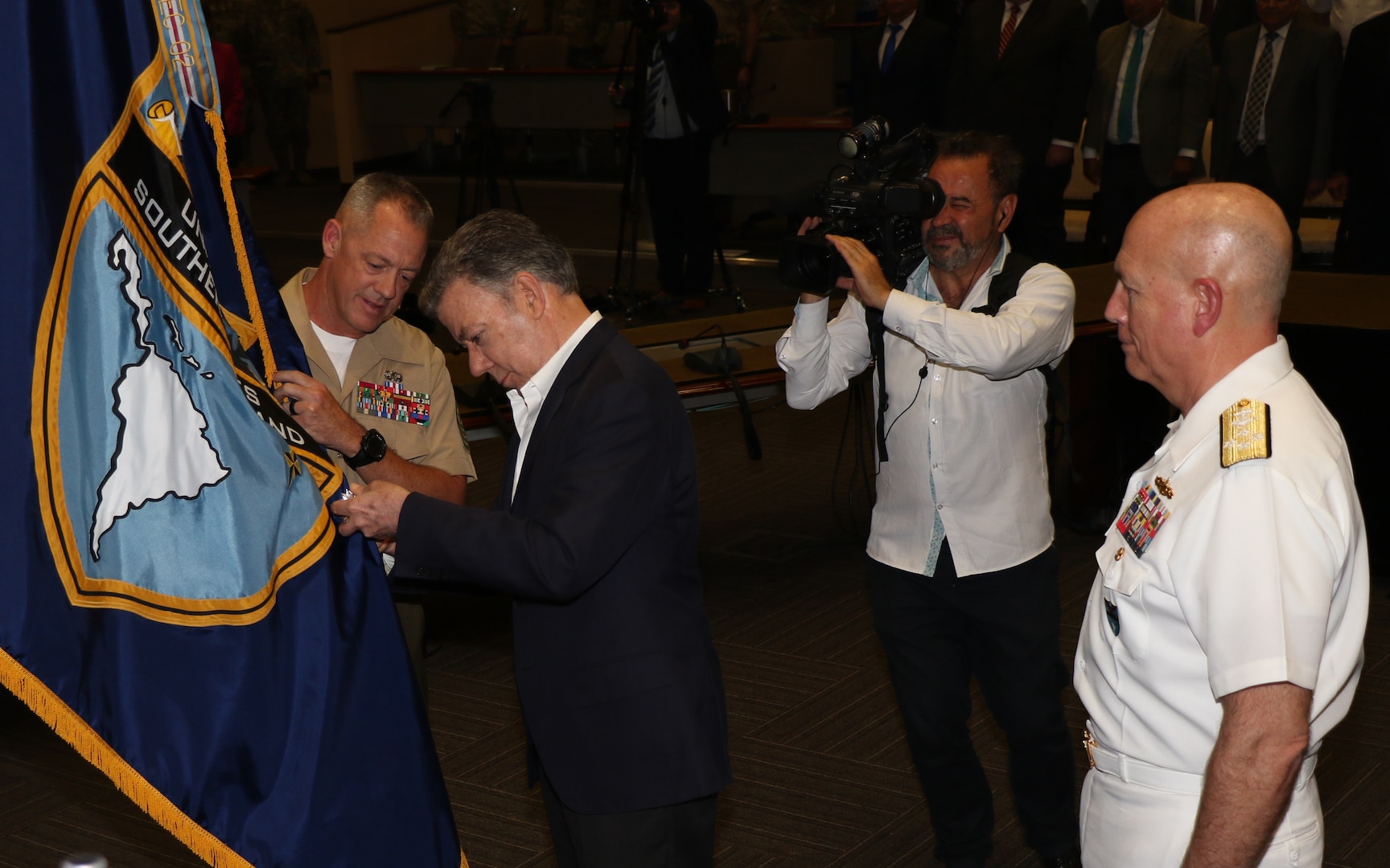 Colombian President Juan Manuel Santos pins the Orden of San Carlos  Medal to the U.S. Southern Command flag