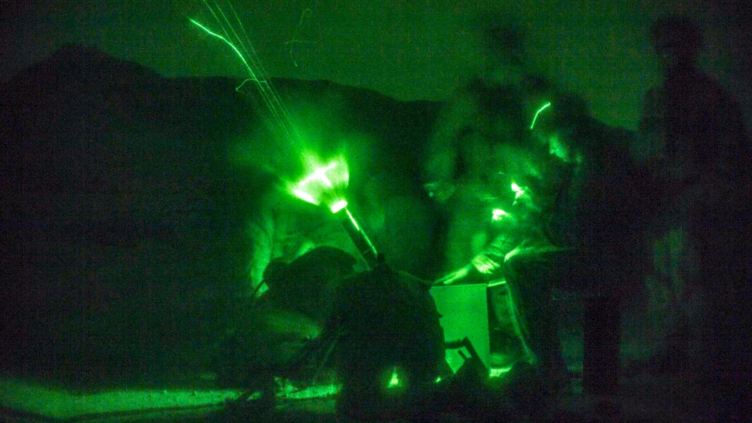 Marines, seen through a night vision device, fire an M224A1 60 mm mortar system.