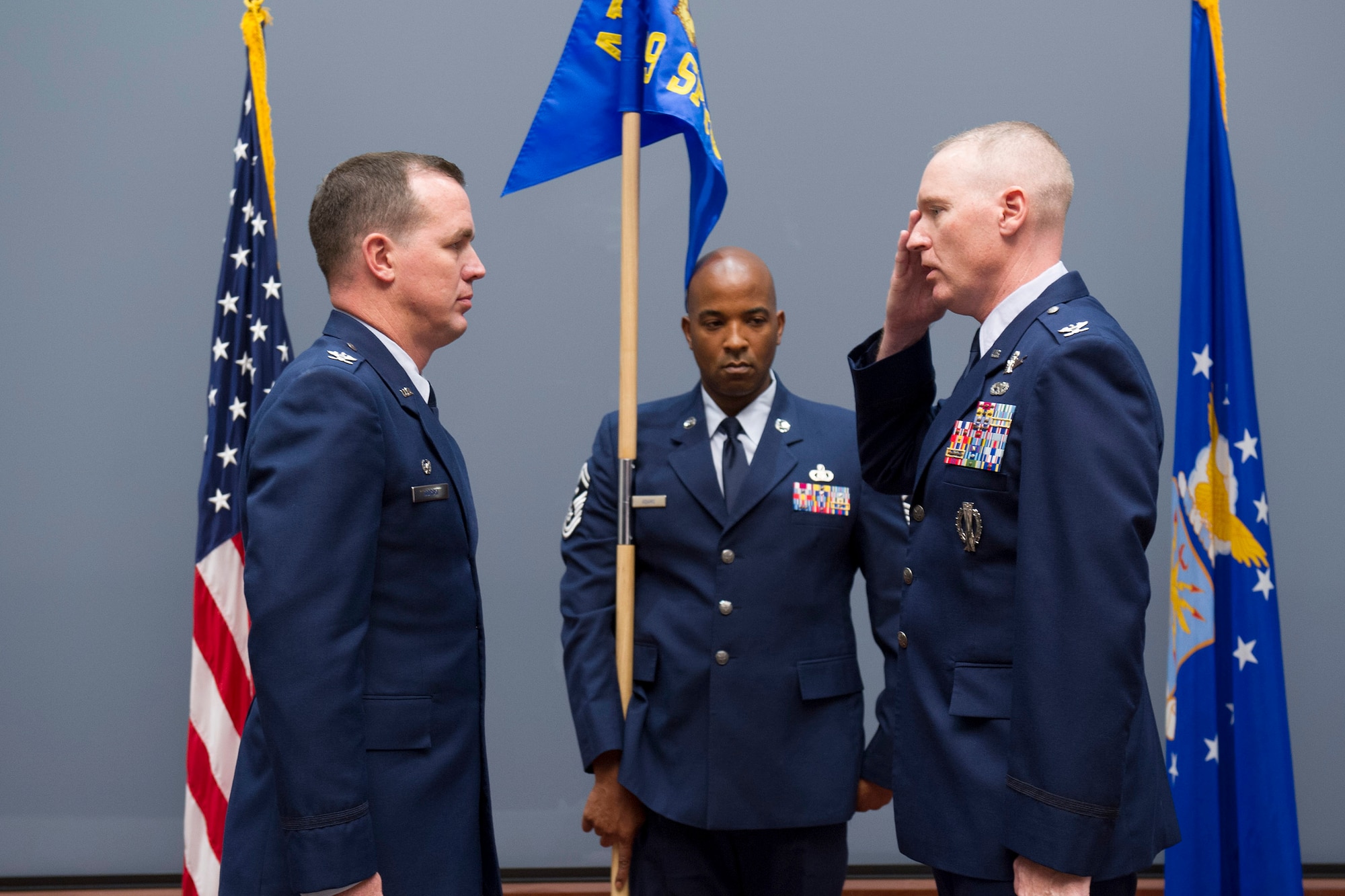 Col. Richard Mendez (right), commander of the newly-activated 709th Support Group, salutes and accepts command from Col. Steven M. Gorski (left), commander of the Air Force Technical Applications, Patrick AFB, Fla.  Holding the guidon is Senior Master Sgt. Braderick Adams, group first sergeant under Mendez’ command.  (U.S. Air Force photo by Phillip C. Sunkel IV)