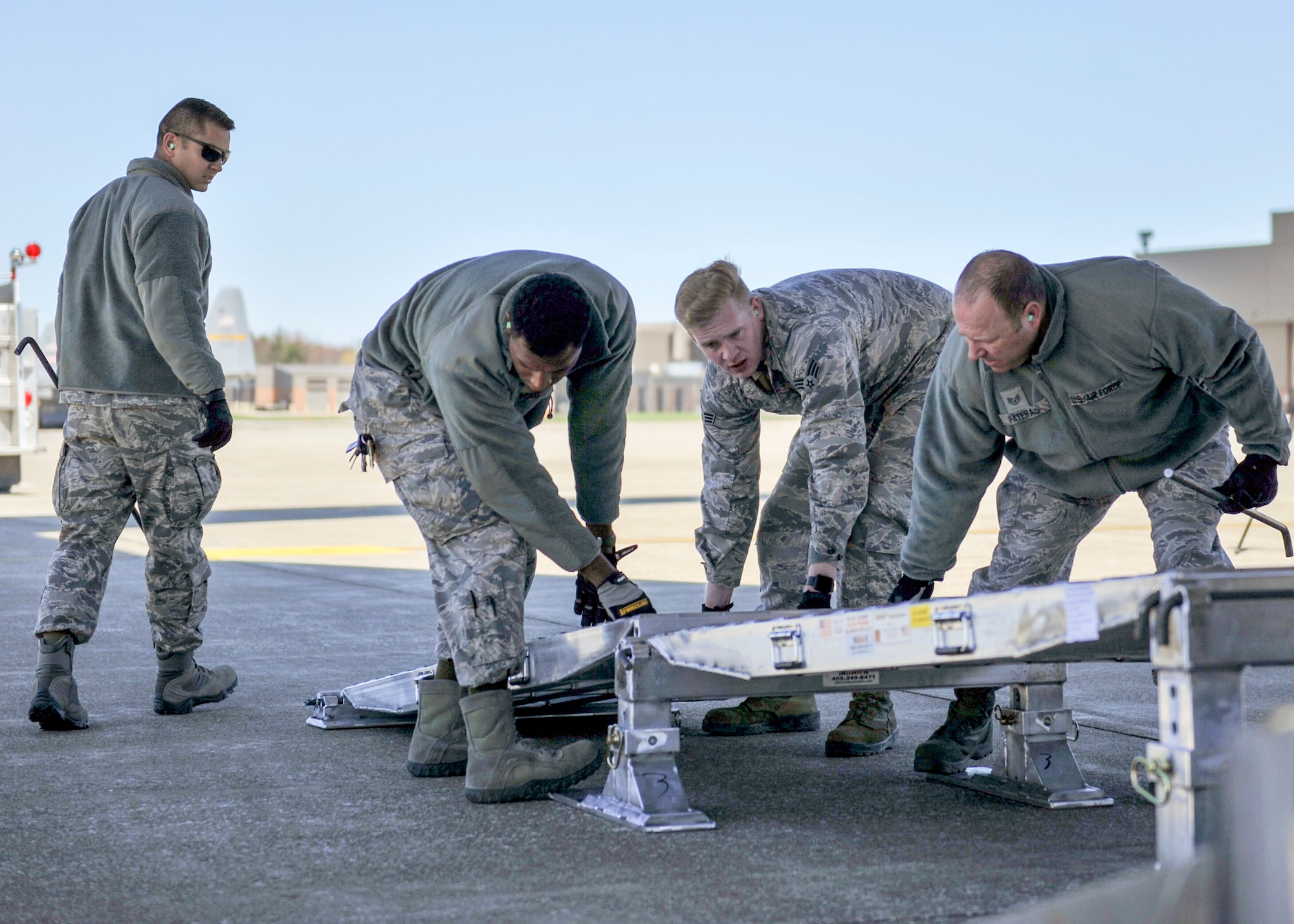 Airmen assigned to the 76th Aerial Port Squadron build a ramp behind a C-17 Globemaster III parked on the Youngstown Air Reserve Station flightline April 20, 2018.