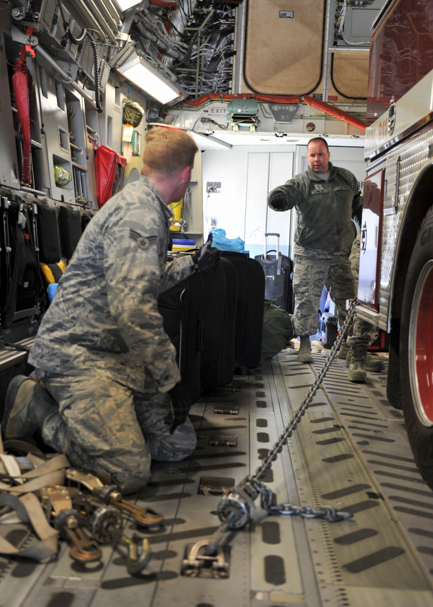 Senior Airman Andrew Flint, a loadmaster with the 21st Airlift Squadron at Travis Air Force Base, California, directs an Austintown Township fire truck driven by Master Sgt. Chris Hornick, Air Terminal Operations Center Section noncommissioned officer in charge with the 76th Aerial Port Squadron, into the back of a C-17 Globemaster III on the flightline here, April 20, 2018.