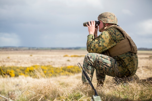 Lance Cpl. Dalton Vandervoort, a forward observer with 4th Air Naval Gunfire Liaison Company, Force Headquarters Group, watches as helicopters fly over a projected target at the Tain Gunfire Range in Tain, Scotland, April 24, 2018.