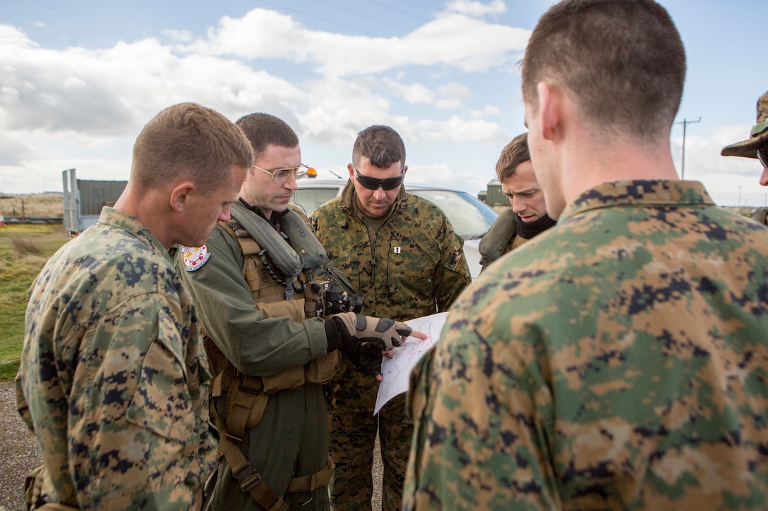 Marines with 4th Air Naval Gunfire Liaison Company, Force Headquarters Group, and sailors with Helicopter Sea Combat Squadron 22, discuss target locations during a close air support exercise at the Tain Gunfire Range in Tain, Scotland, April 24, 2018.