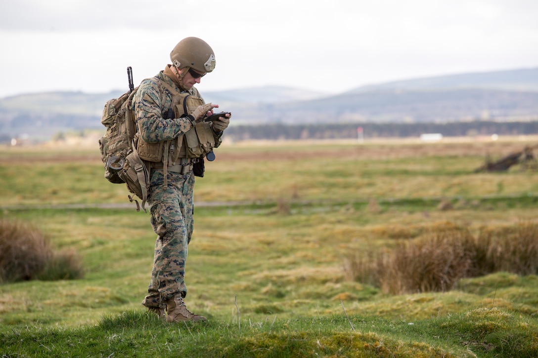 Maj. Graham Perry, the officer in charge of 4th Air Naval Gunfire Liaison Company, Force Headquarters Group, checks his Android Tactical Assault Kit to see possible target areas at the Tain Gunfire Range in Tain, Scotland, April 24, 2018.
