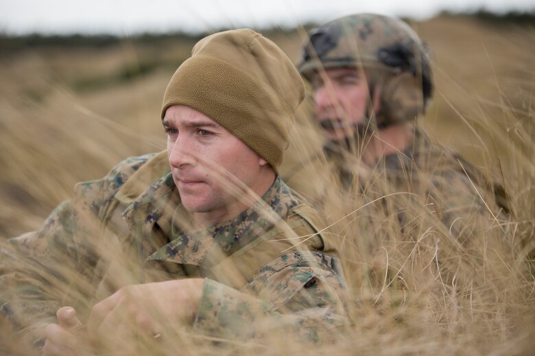 Sgt. Andrew Snow (left), a firepower control team chief with 4th Air Naval Gunfire Liaison Company, Force Headquarters Group, and Capt. Ryan Mathews (right), a firepower control team leader with 4th ANGLICO, FHG, watch as helicopters circle around a projected target at the Tain Gunfire Range in Tain, Scotland, April 24, 2018.