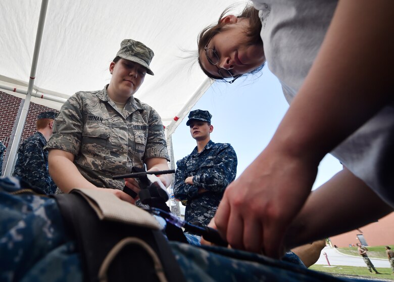 Airman 1st Class Amanda Keenan, left, and Airman 1st Class Anabell Salcedo, right, both with the 628th Medical Group, practice applying a tourniquet to a simulated casualty during the 3rd Annual Joint Skills Expo at the Joint Base Charleston Naval Health Clinic April 18, 2018, in Charleston, S.C.