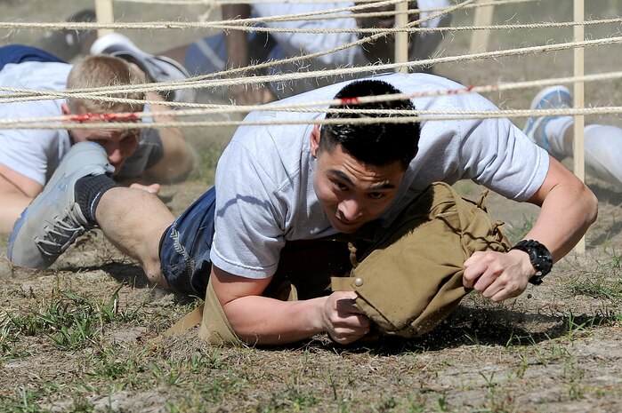 Senior Airman Miguel Buenaflor, 628th Aerospace Medicine Squadron Flight Medicine, base operation medicine cell technician, low crawls with a medical kit on the first obstacle during the 3rd Annual Lowcountry Skills Expo here, April 18, 2018.