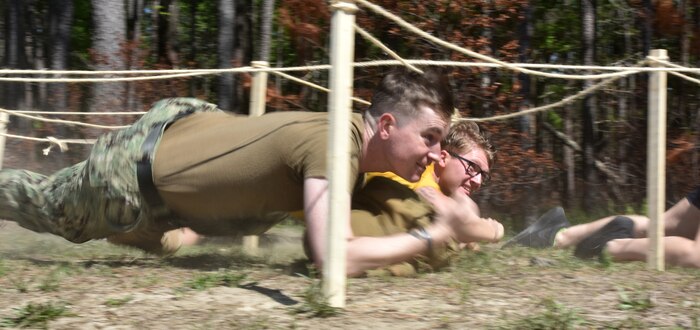 U.S. Navy Sailors from Joint Base Charleston, S.C., low crawl through an obstacle during the 3rd Annual Joint Skills Expo’s medical skills Olympics April 18, 2018, at Naval Health Clinic Charleston.