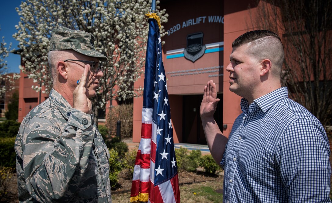Lt. Col. Stan Paregien listens to one of the wing's newest recruits, Ryan Hill, as he recites the oath of enlistment.  He later talked about going into the medical area, and he smiled with pride as family members witnessed the historical moment as he enlisted into the 932nd Airlift Wing. He raised his right hand and promised to "support and defend the Constitution of the United States", coming into the Air Force Reserve and the 932nd Airlift Wing on April 17, 2018, at Scott Air Force Base.  His recruiter, Master Sgt. Tabetha Coley, works the St. Peters side of the river in Missouri.  Those who want to refer a friend to the unit can call 1-800-257-1212.  (U.S. Air Force photo by Christopher Parr)