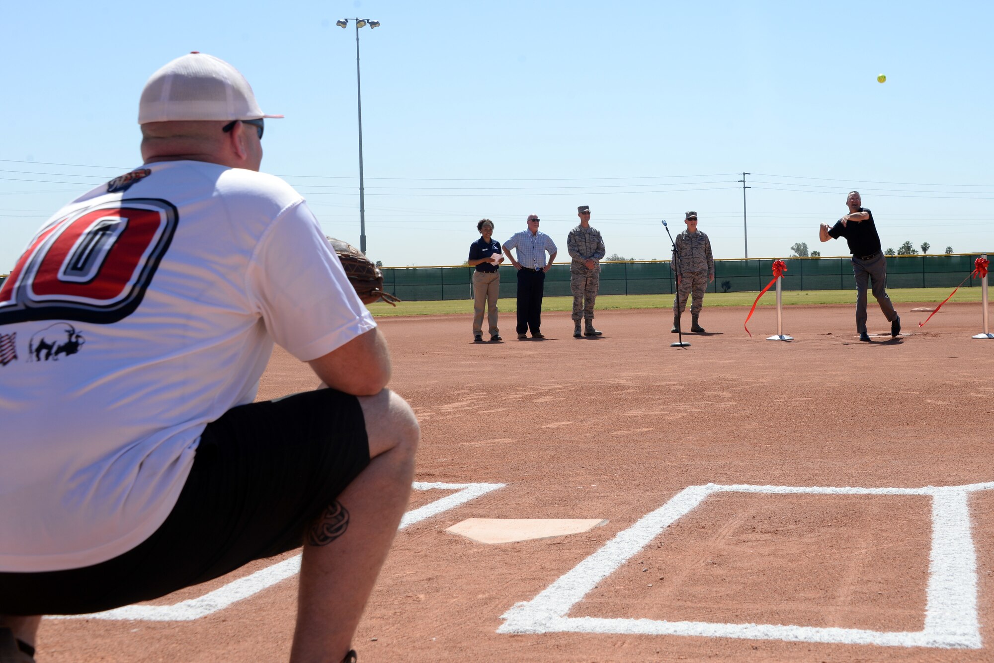 Mark Grace, former Arizona Diamondbacks first baseman, throws the ceremonial pitch during the scoreboard ribbon cutting ceremony April 23, 2018, at Luke Air Force Base, Ariz. The Diamondbacks, together with Arizona Public Service, presented Luke AFB with a new scoreboard for field number three. (U.S. Air Force photo by Senior Airman Devante Williams)