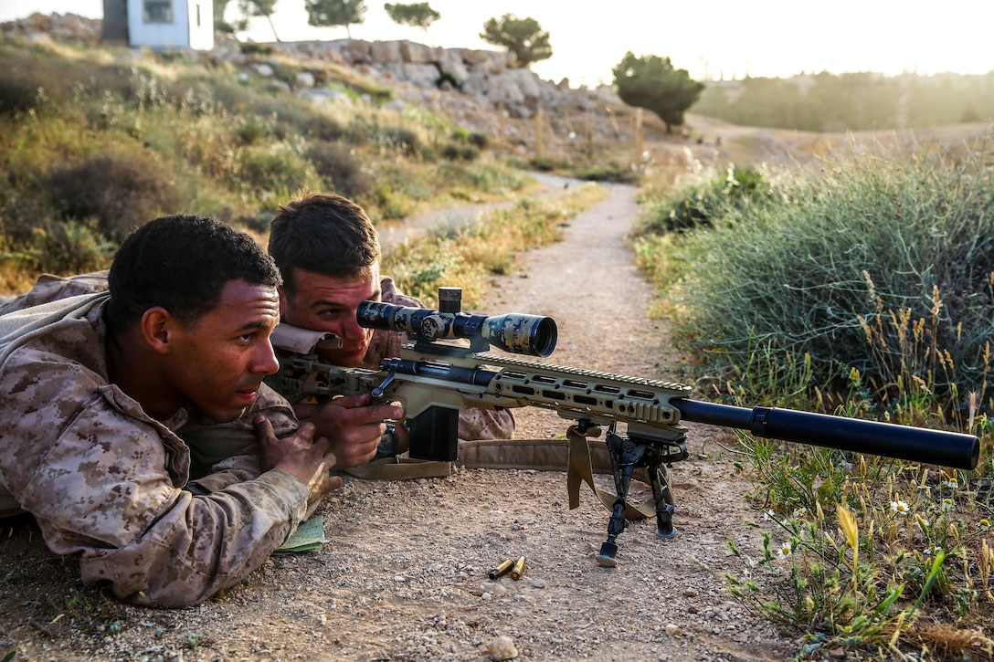 A U.S. Navy Sailor assigned to Scout Sniper Platoon, Weapons Company, Battalion Landing Team, 2nd Battalion, 6th Marine Regiment (BLT 2/6), 26th Marine Expeditionary Unit (MEU), scans for targets during Eager Lion at the King Abdullah II Special Operations Training Center, Jordan, April 18, 2018.