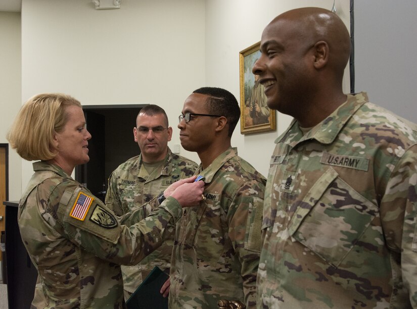 Col. Kathleen Porter, commander of the 83rd U.S. Army Reserve Readiness Training Center, 100th Training Division commander, awards Staff Sgt. Paris Bledsoe, 5th Brigade Health Services, 94th Training Division – Force Sustainment, for competing in the 80th Training Command’s Best Warrior Competition and winning his division’s top honors during the competition's awards ceremony. (U.S. Army Reserve photo by Maj. Addie Leonhardt, 80th Training Command)