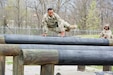 Staff Sgt. Paris Bledsoe, assigned to the 5th Brigade Health Services, 94th Training Division – Force Sustainment, jumps over multiple raised logs in the obstacle course portion of the 80th Training Command's 2018 Best Warrior Competition at Fort Knox, Kentucky, April 14, 2018. (U.S. Army Reserve photo by Maj. Addie Leonhardt, 80th Training Command)