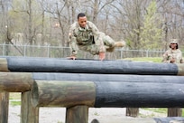 Staff Sgt. Paris Bledsoe, assigned to the 5th Brigade Health Services, 94th Training Division – Force Sustainment, jumps over multiple raised logs in the obstacle course portion of the 80th Training Command's 2018 Best Warrior Competition at Fort Knox, Kentucky, April 14, 2018. (U.S. Army Reserve photo by Maj. Addie Leonhardt, 80th Training Command)