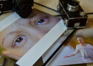 Cameras and photographs taken by U.S. Army Spc. Wilmarys Roman Rivera, Headquarters and Headquarters Company, 10th Battalion, 7th Transportation Brigade (Expeditionary) tactical power generation specialist, are placed in her dorm at Joint Base Langley-Eustis, Virginia, April 20, 2018. Roman Rivera worked to capture the inner turmoil she faced while battling breast cancer. (U.S. Air Force photo by Airman 1st Class Monica Roybal)