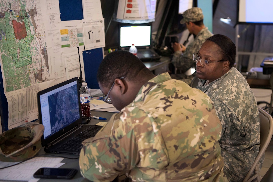 Soldiers reviews satellite map imagery.