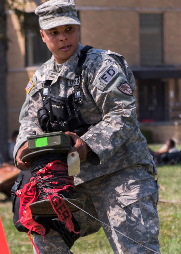 A soldier rolls out communications wire.