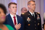 Aaron Hall, the 2018 Operation Homefront National Guard military child of the year, stands during the National Anthem at a gala event held in Arlington, Va., April 19, 2018. Joining Aaron was Lt. Gen Daniel R. Hokanson, the 11th Vice Chief of the National Guard Bureau.