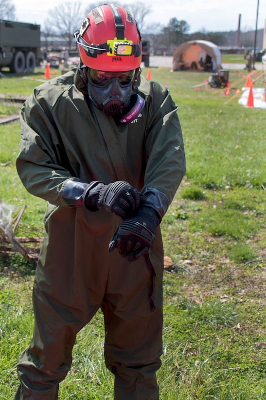 A soldier puts on her protective gear.