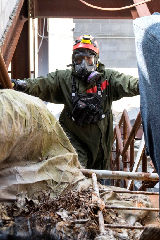 A soldier climbs a debris-covered staircase.