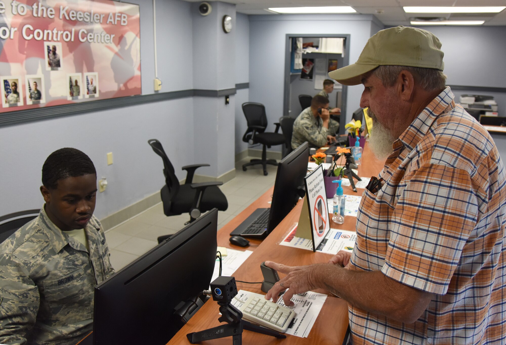 Airman 1st Class Leonard Brown, 81st Security Forces visitors center clerk, provides a Gold Star Family Member ID card to Joey Roberts, Gold Star Family Member at the visitor center at Keesler Air Force Base, Mississippi, April 24, 2018. As a surviving parent of a killed in action service member, Roberts is allowed to obtain an ID card for recognition and installation access so he can attend events and access Airmen and Family Readiness Center referral services. (U.S. Air Force photo by Kemberly Groue)